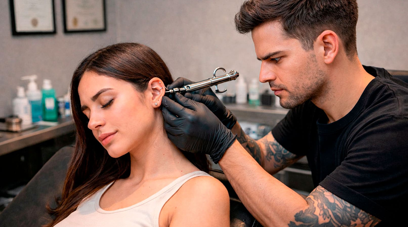 Profesional de piercing haciendo una perforación a una cliente en un centro autorizado en Madrid.