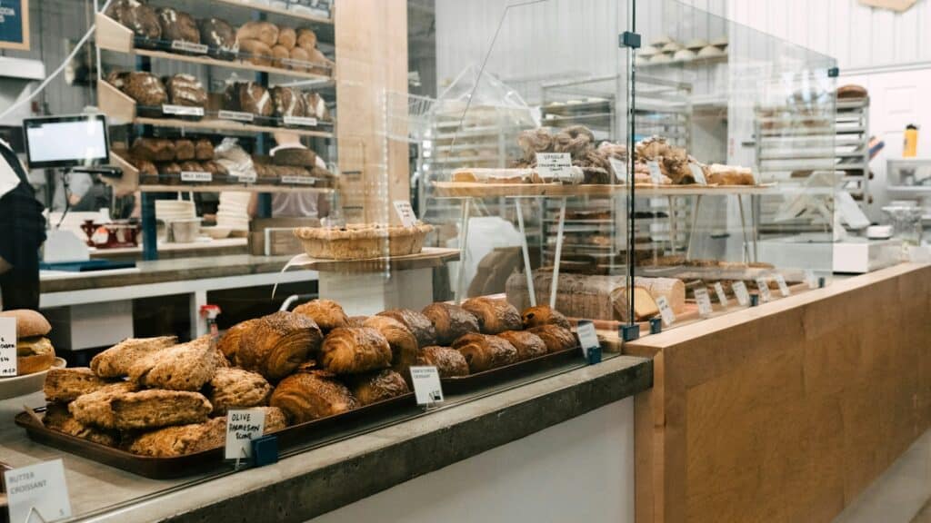 Mostrador de una panadería con panes y bollería protegidos tras una vitrina